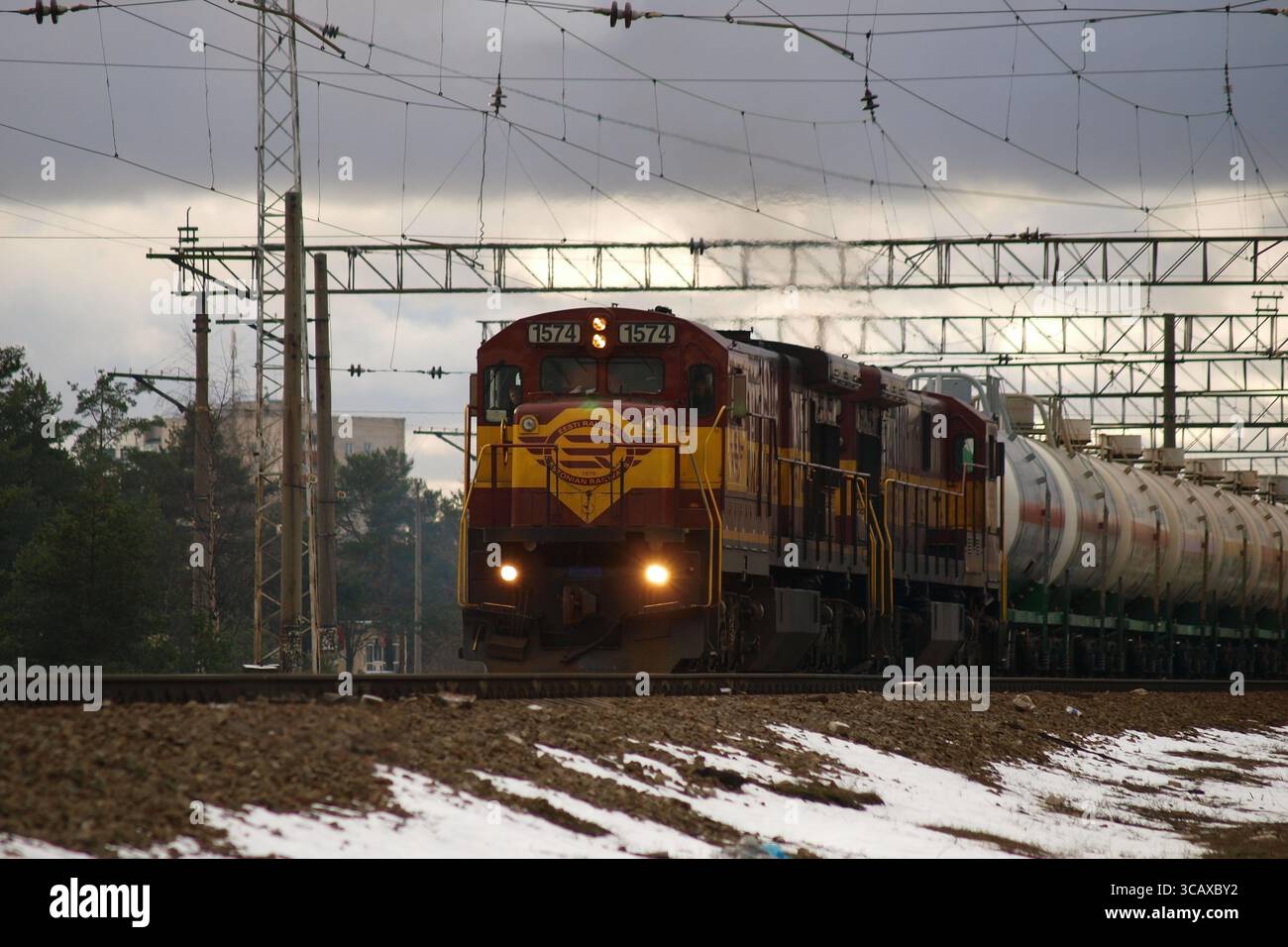 La locomotive diesel numéro 1574 des chemins de fer estoniens (EVR) mène une longue série de wagons-citernes à travers un paysage hivernal enneigé en Estonie le 27 janvier Banque D'Images