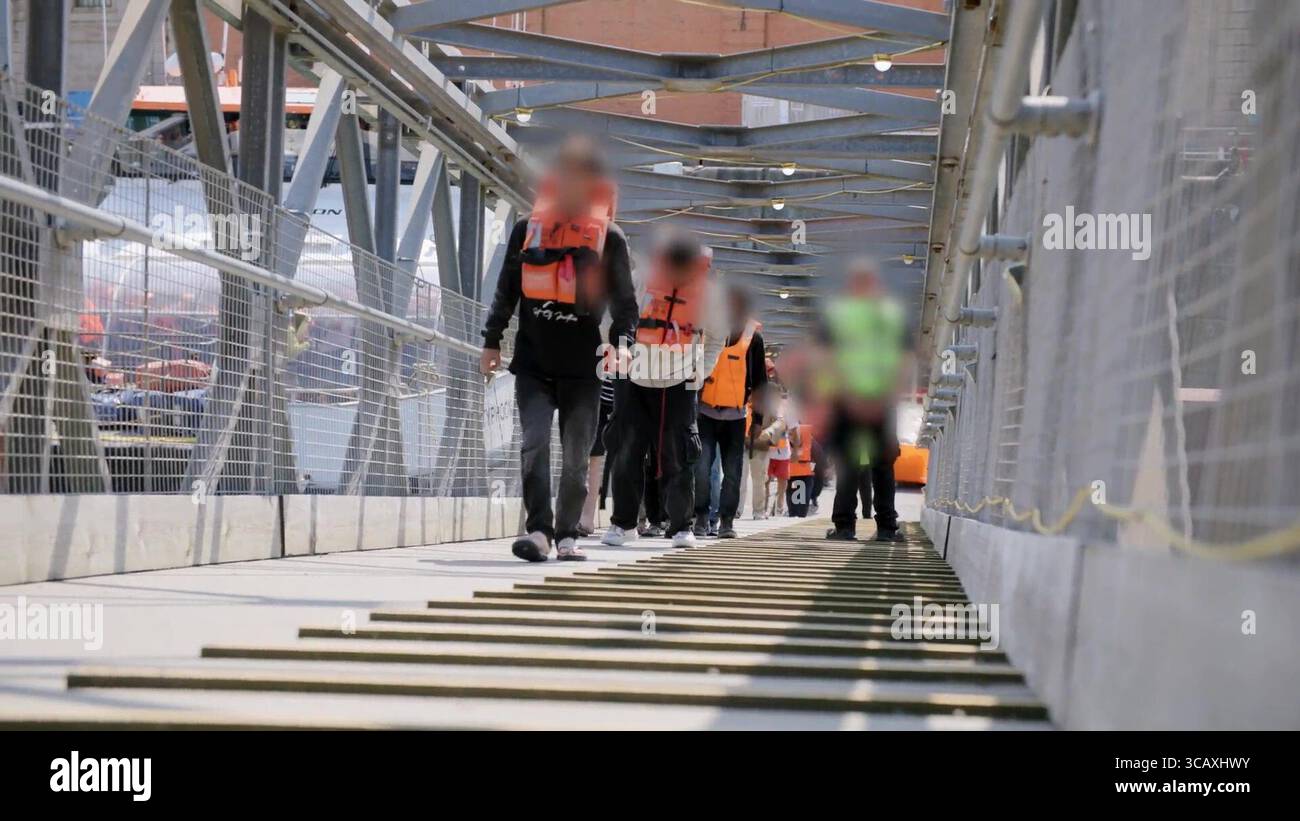 NOTE DE LA RÉDACTION - LES IMAGES SONT FLOUES À LA SOURCE. Capture d'écran tirée d'une vidéo publiée par le Home Office des premiers migrants de petits bateaux détenus dans le cadre du nouveau contrat « One In, One Out » du Royaume-Uni, à Western Jet Foil à Douvres, dans le Kent. Les migrants, qui ont été détenus le jour où le projet pilote a commencé à fonctionner, passent par les premières étapes du processus pilote de retour Royaume-Uni-France au cours des dernières 24 heures, y compris le traitement initial, les contrôles biométriques et de sécurité, et la réinstallation au Centre de renvoi de l'immigration pour attendre leur retour en France. Date de la photo : jeudi 7 août 2025. Banque D'Images