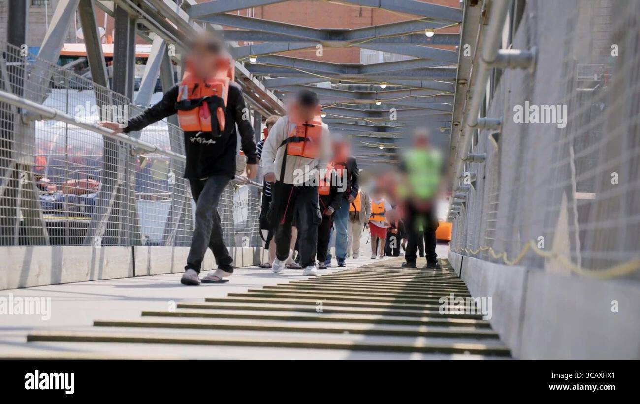 NOTE DE LA RÉDACTION - LES IMAGES SONT FLOUES À LA SOURCE. Capture d'écran tirée d'une vidéo publiée par le Home Office des premiers migrants de petits bateaux détenus dans le cadre du nouveau contrat « One In, One Out » du Royaume-Uni, à Western Jet Foil à Douvres, dans le Kent. Les migrants, qui ont été détenus le jour où le projet pilote a commencé à fonctionner, passent par les premières étapes du processus pilote de retour Royaume-Uni-France au cours des dernières 24 heures, y compris le traitement initial, les contrôles biométriques et de sécurité, et la réinstallation au Centre de renvoi de l'immigration pour attendre leur retour en France. Date de la photo : jeudi 7 août 2025. Banque D'Images