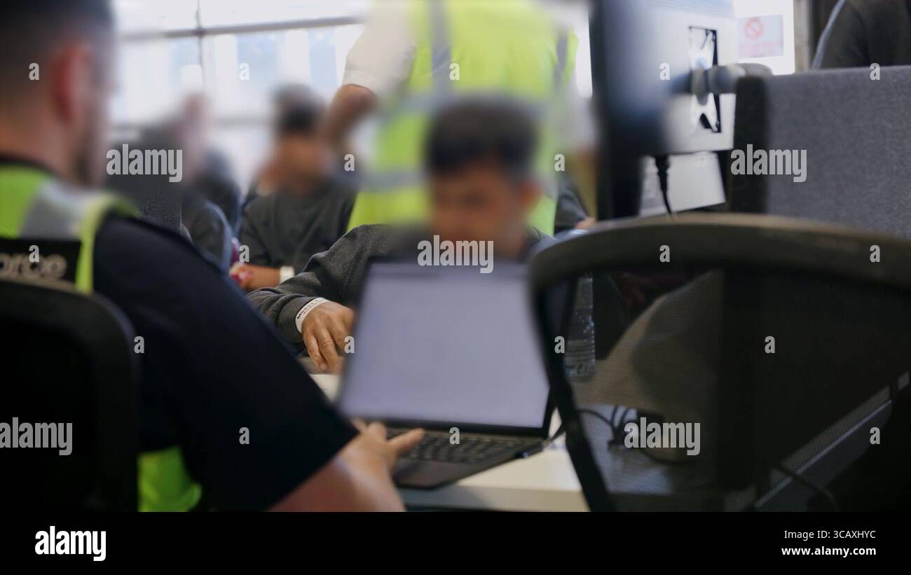 NOTE DE LA RÉDACTION - LES IMAGES SONT FLOUES À LA SOURCE. Capture d'écran tirée d'une vidéo publiée par le Home Office of Border Force Officers traitant les premiers migrants par bateau détenus dans le cadre du nouveau contrat « One in, One out » du Royaume-Uni, au Centre de traitement des demandes d'immigration de Manston, dans le Kent. Les migrants, qui ont été détenus le jour où le projet pilote a commencé à fonctionner, passent par les premières étapes du processus pilote de retour Royaume-Uni-France au cours des dernières 24 heures, y compris le traitement initial, les contrôles biométriques et de sécurité, et la réinstallation au Centre de renvoi de l'immigration pour attendre leur retour en France. Image Banque D'Images