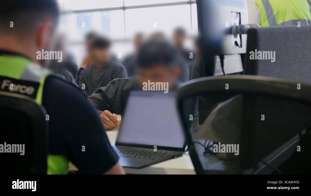 NOTE DE LA RÉDACTION - LES IMAGES SONT FLOUES À LA SOURCE. Capture d'écran tirée d'une vidéo publiée par le Home Office of Border Force Officers traitant les premiers migrants par bateau détenus dans le cadre du nouveau contrat « One in, One out » du Royaume-Uni, au Centre de traitement des demandes d'immigration de Manston, dans le Kent. Les migrants, qui ont été détenus le jour où le projet pilote a commencé à fonctionner, passent par les premières étapes du processus pilote de retour Royaume-Uni-France au cours des dernières 24 heures, y compris le traitement initial, les contrôles biométriques et de sécurité, et la réinstallation au Centre de renvoi de l'immigration pour attendre leur retour en France. Image Banque D'Images