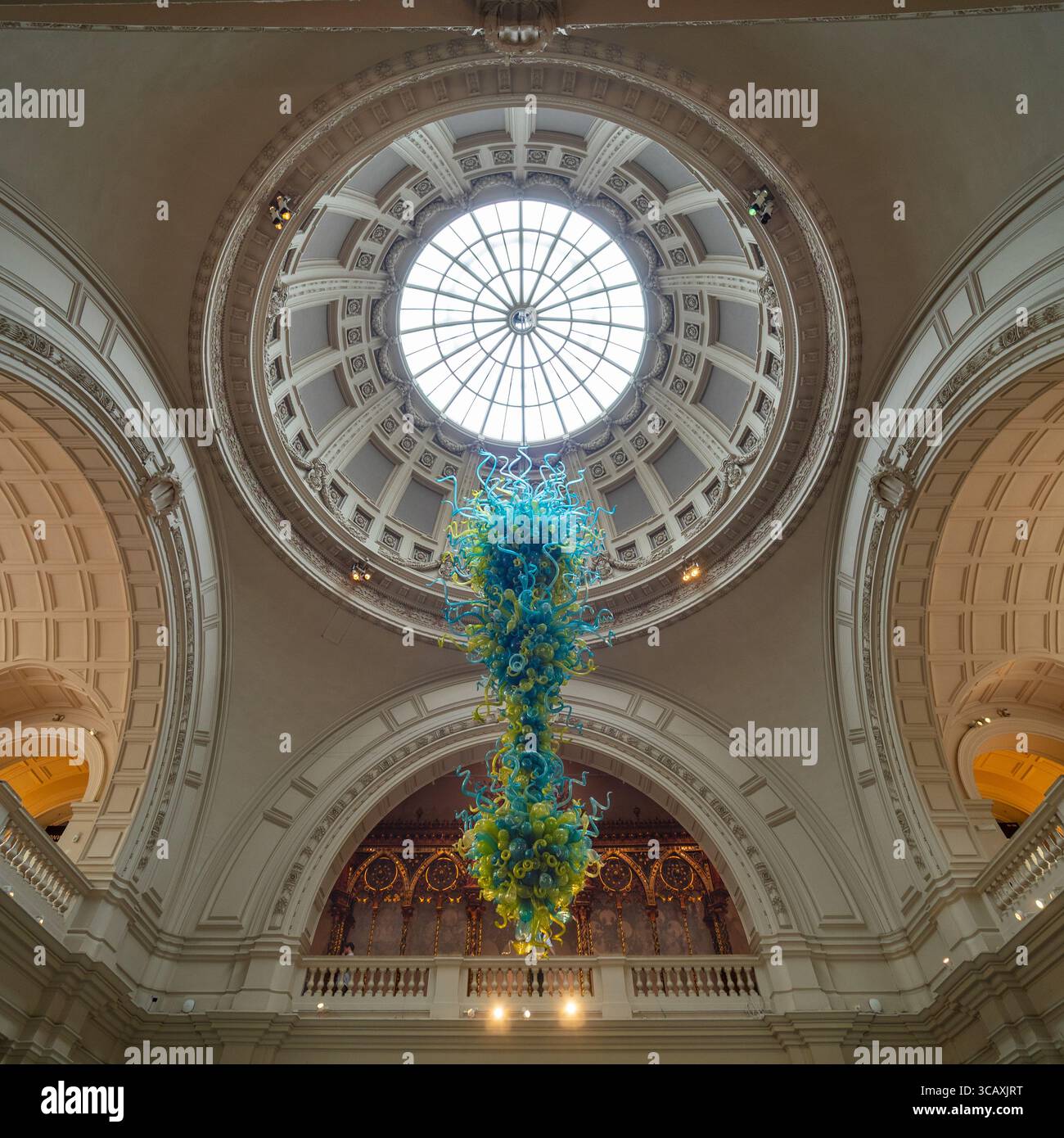 Le « V&A Chandelier » bleu et jaune de Dale Chihuly, un superbe exemple d'art du verre moderne, au Victoria and Albert Museum, Londres, Royaume-Uni. Banque D'Images