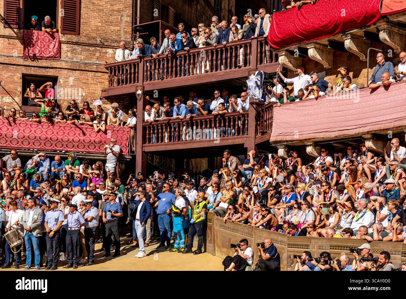 Siennois dans les tribunes et les juges attendent le début d'Une course d'essai matinale pendant les quatre jours du Palio, Sienne, Toscane, Italie. Banque D'Images