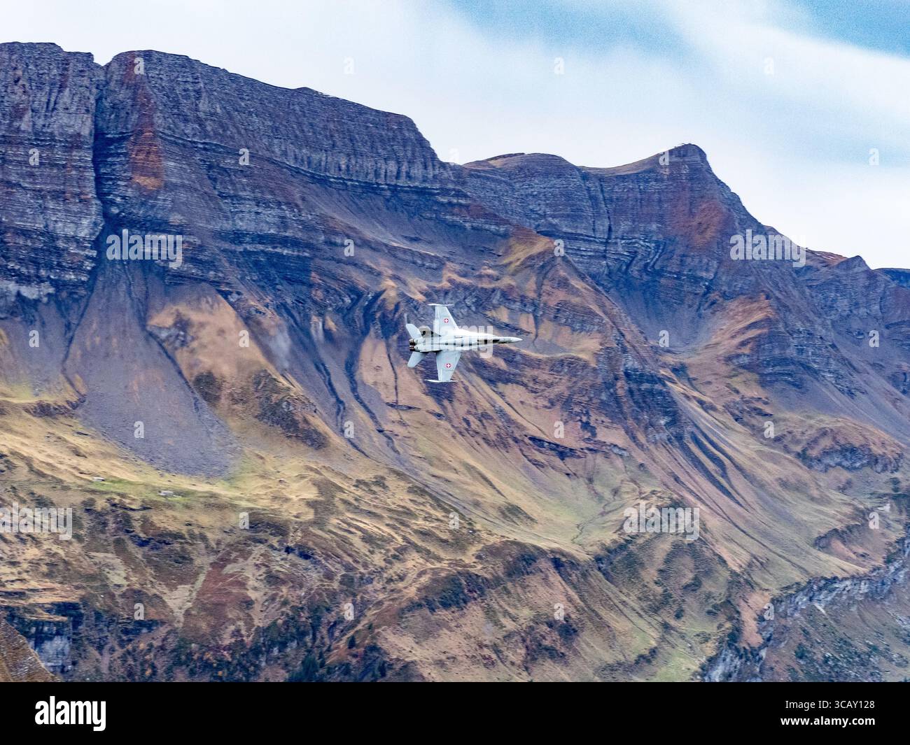 F/A-18 Hornet Jet Fighter de l'armée de l'air suisse volant à basse altitude au-dessus du paysage des montagnes alpines Banque D'Images