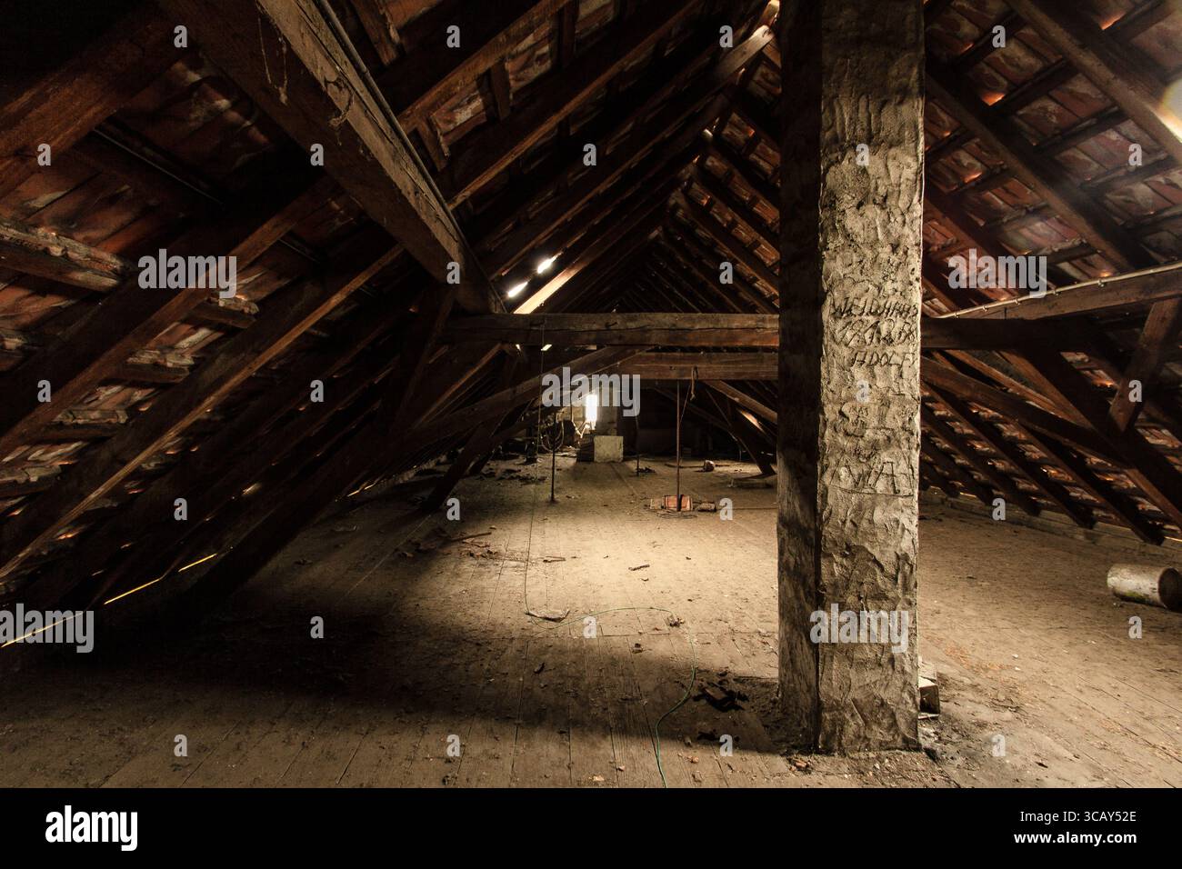 Ancien grenier spacieux avec poutres en bois et structure de toit rustique éclairé par la lumière naturelle Banque D'Images