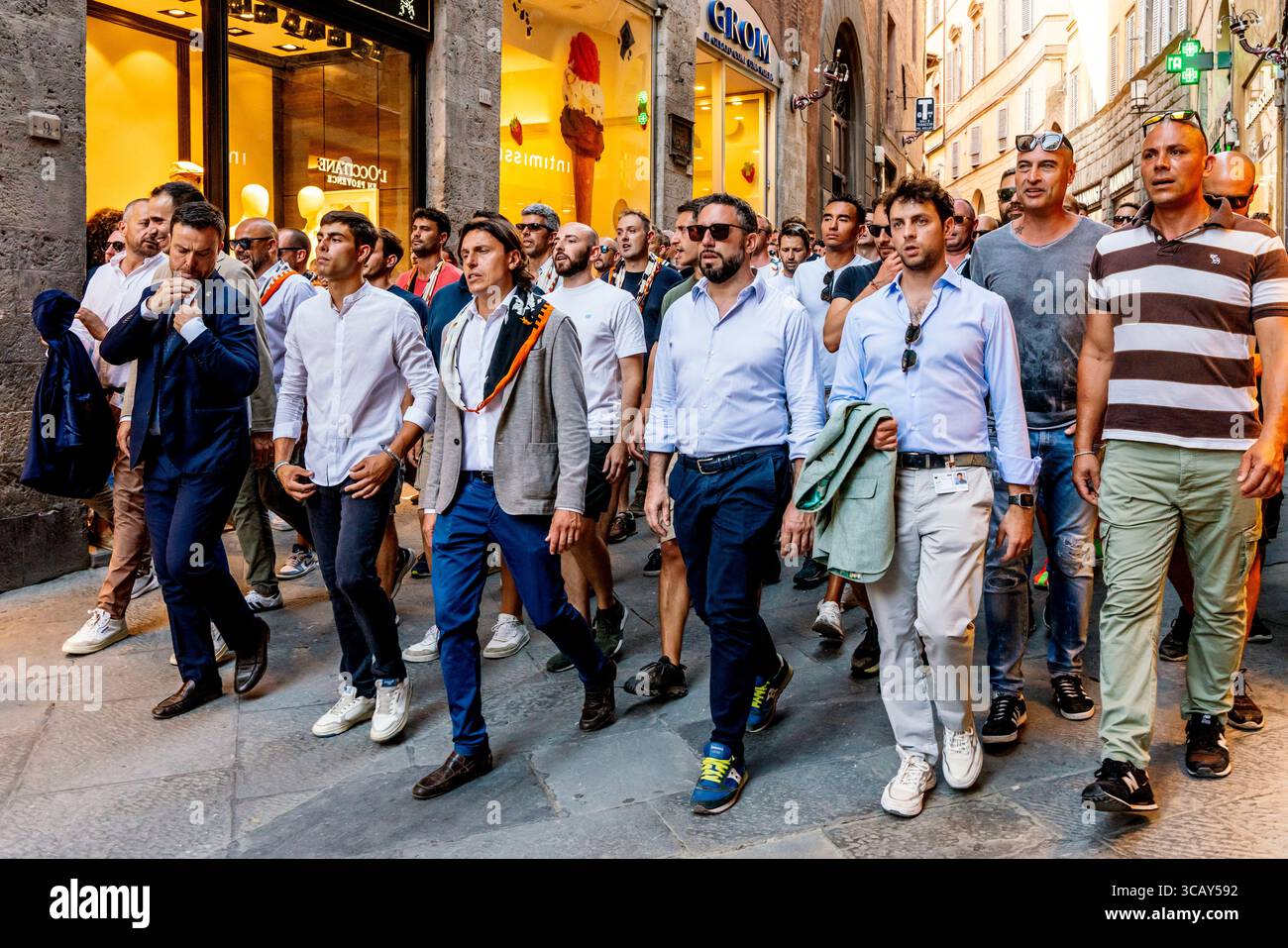 La Lupa (She Wolf) Contrada fait leur chemin à travers les rues de la ville à la Piazza del Campo pour une course de procès en soirée, le Palio, Sienne, Italie. Banque D'Images