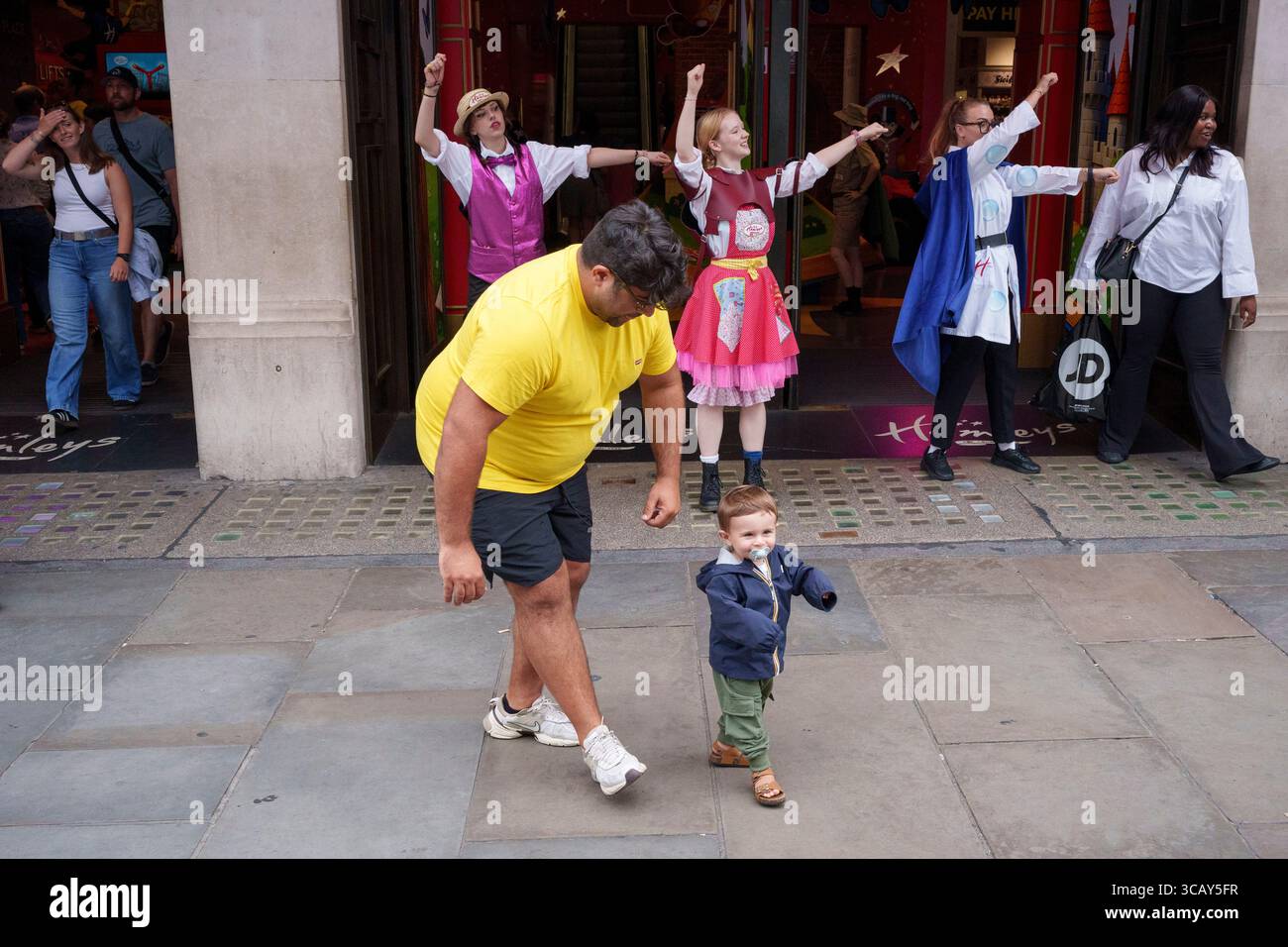 Un jeune enfant rejoint les danseurs devant le magasin de jouets Hamleys sur Regent Street dans le West End, le 7 août 2025, à Londres, en Angleterre. Banque D'Images