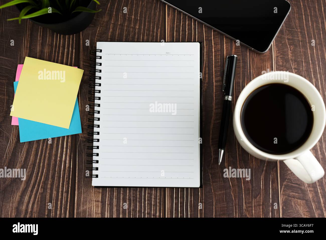 Vue de dessus du bloc-notes vierge, note adhésive, tasse de café sur la table en bois Banque D'Images