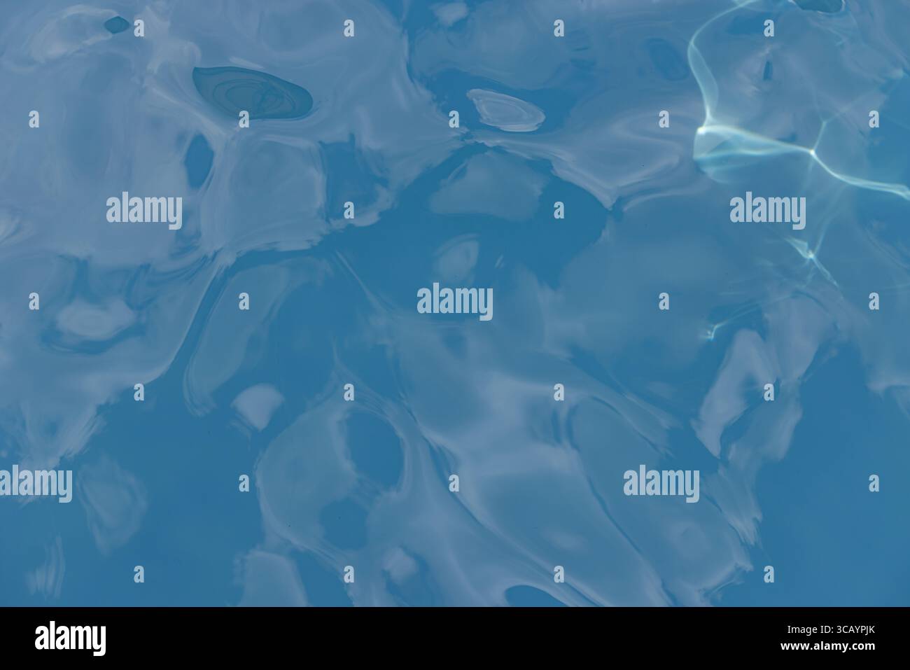 Lumière du soleil créant de belles ondulations à la surface de l'eau. Banque D'Images