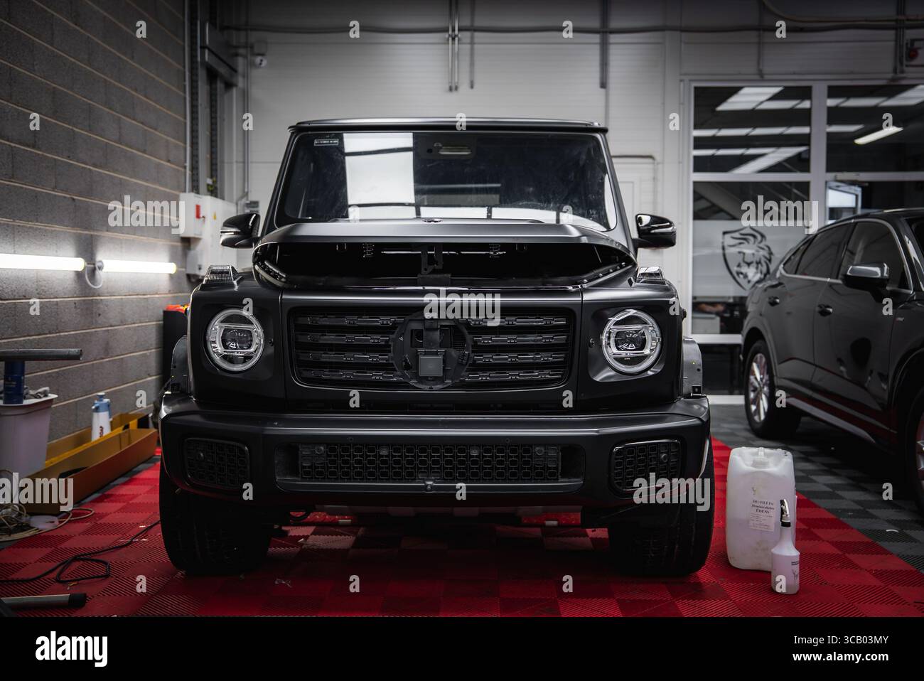 Noir Mercedes classe G SUV avec capot ouvert dans le garage du magasin de voitures Banque D'Images