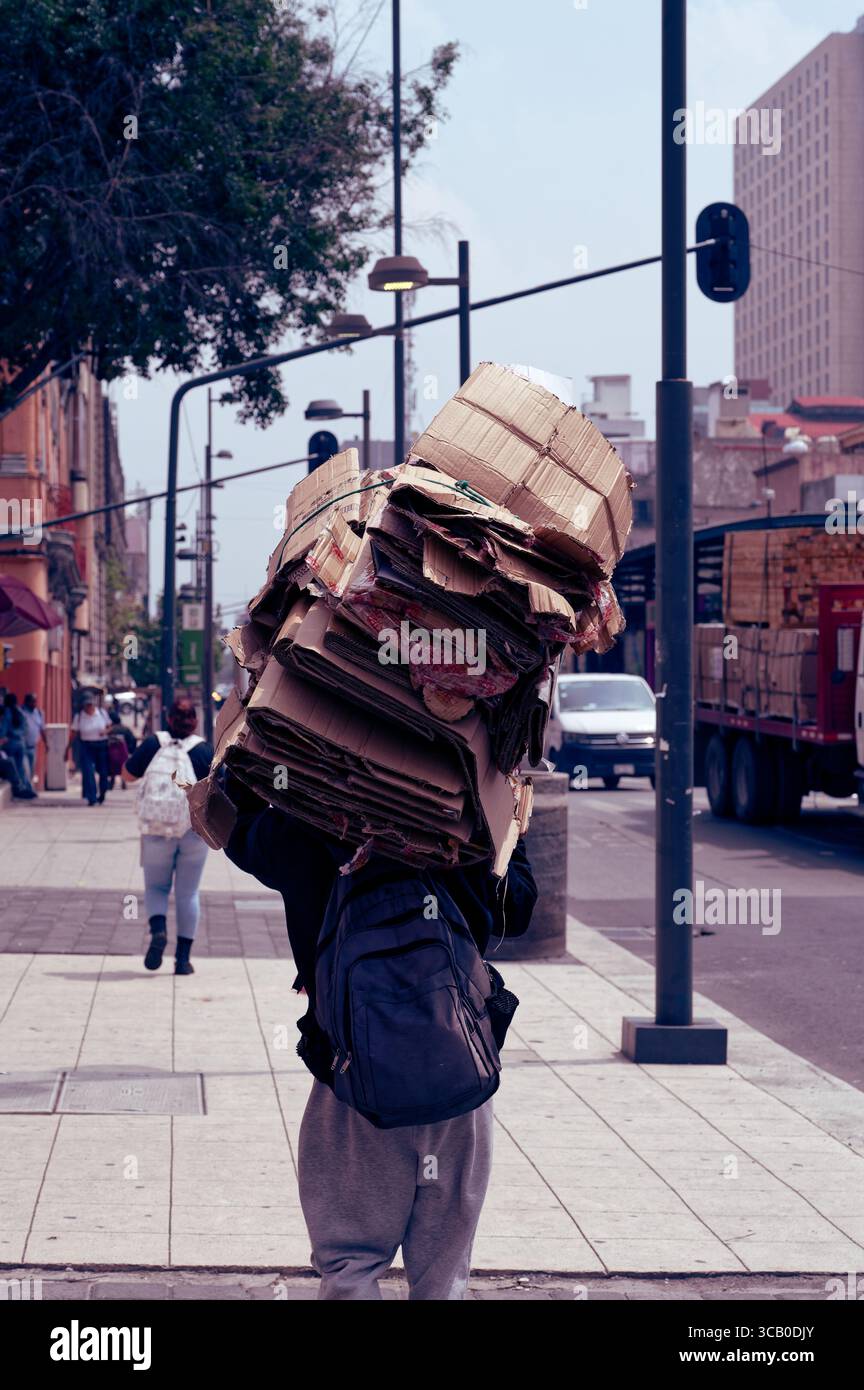 Personne portant une grande pile de boîtes en carton aplaties sur son dos tout en marchant dans les rues de Colonia Centro, Mexico Banque D'Images