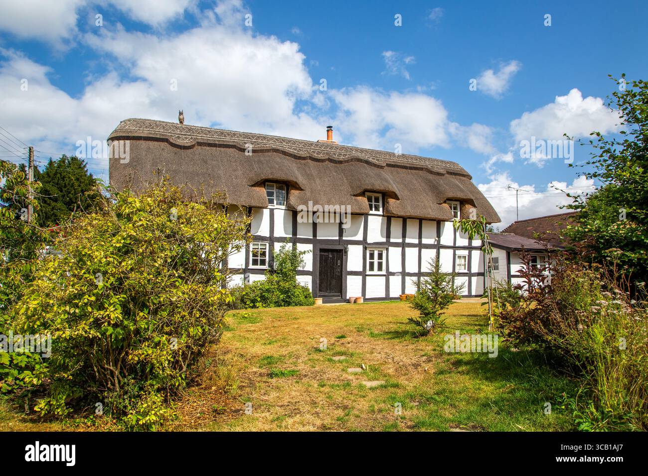 Toad Cottage, une maison traditionnelle anglaise à colombages de chaume dans le village Herefordshire d'Eardisland près de Leominster, sentier noir et blanc Banque D'Images