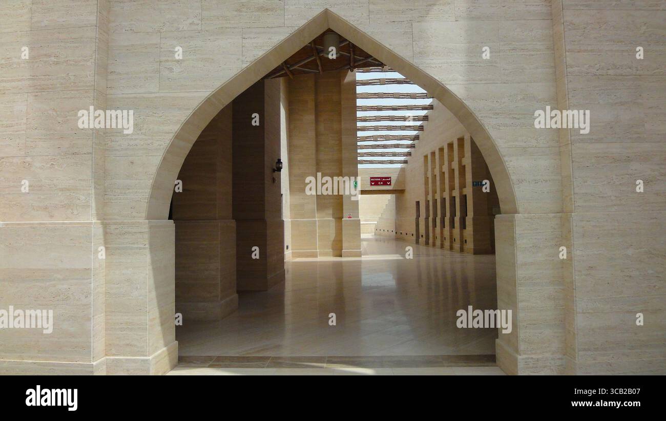 Architecture moderne à l'intérieur d'un bâtiment dans le village culturel Katara, avec une entrée voûtée et un design élégant. Banque D'Images