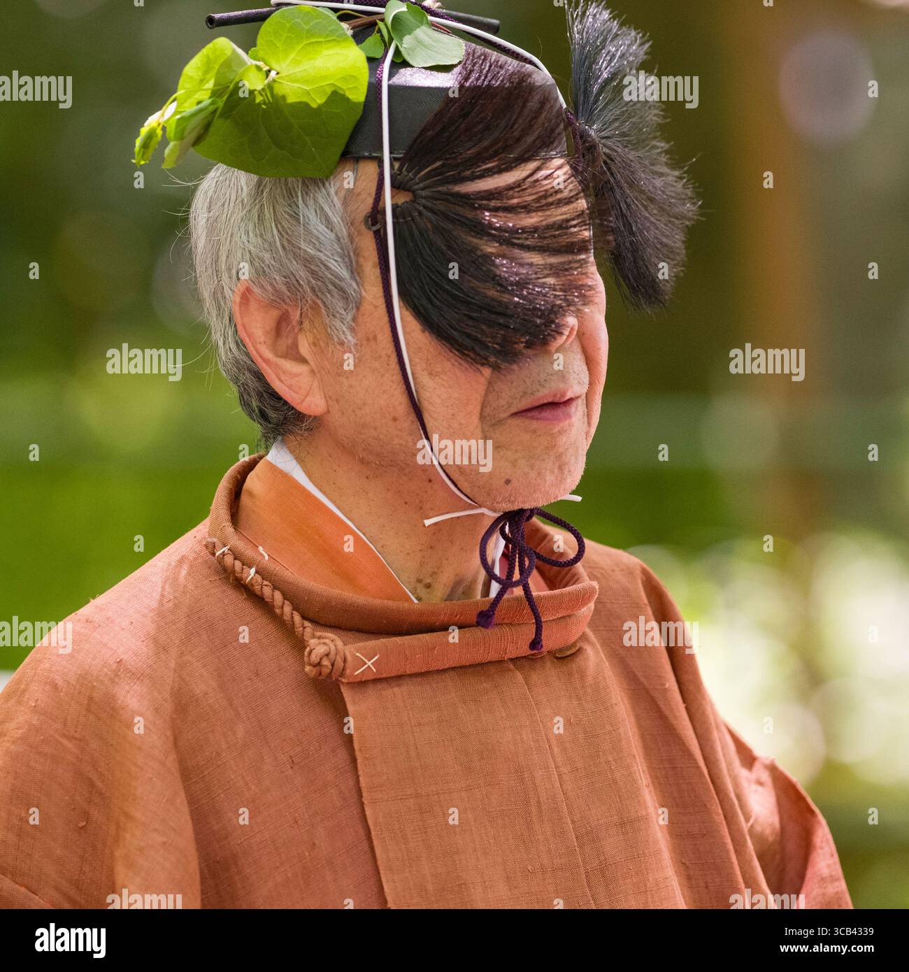 Homme âgé vêtu de vêtements traditionnels japonais et coiffe pendant le festival Yabusame Shinji. La tenue met en valeur le patrimoine culturel Banque D'Images
