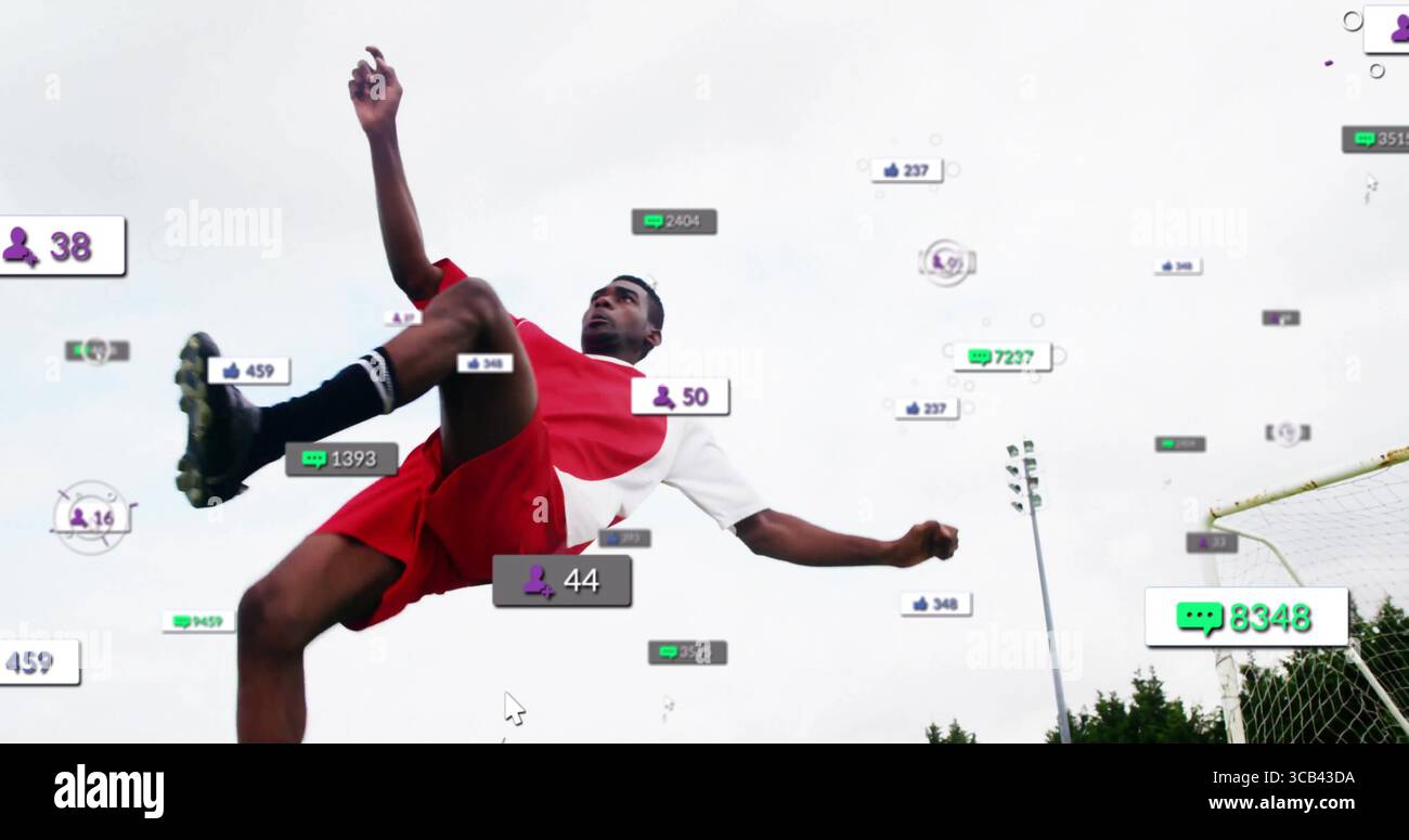 Joueur de football sautant portant un uniforme rouge sur le terrain, avec filet de but et superpositions de médias sociaux Banque D'Images