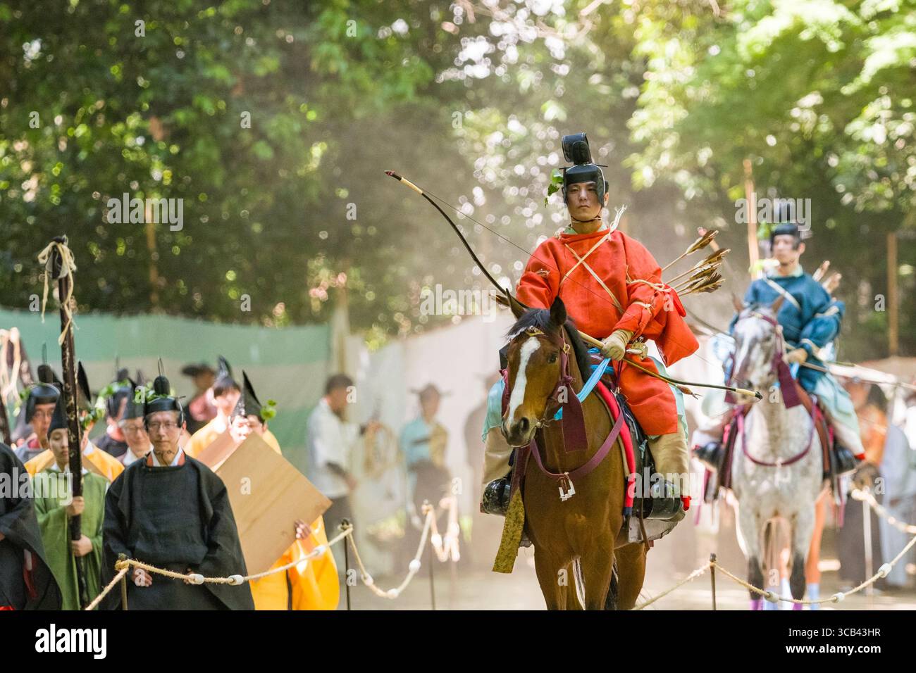 Les participants en tenue traditionnelle japonaise effectuent un tir à l'arc à cheval pendant le festival Yabusame Shinji, mettant en valeur le patrimoine culturel et les compétences. Banque D'Images