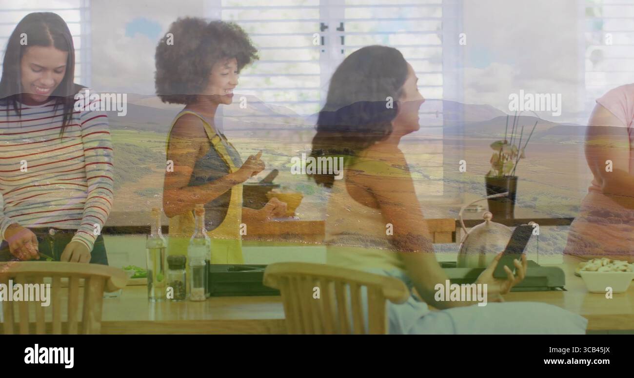 Préparer des amis hachant des légumes et remuant le mélange à l'îlot de cuisine avec superposition de montagne Banque D'Images