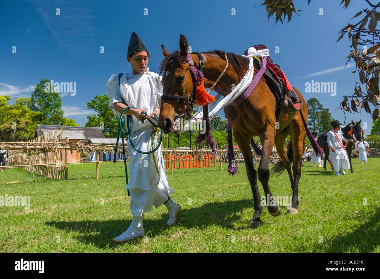 Homme vêtu d'une tenue historique menant un cheval pendant le festival Kamo Kurabeum au sanctuaire Kamigamo, Kyoto, Japon Banque D'Images