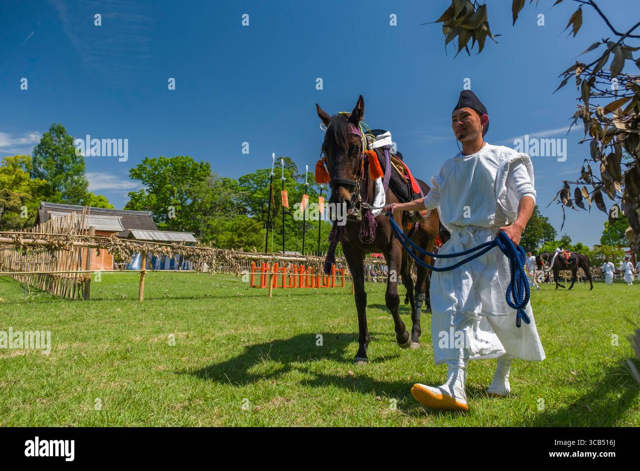 Un homme en tenue traditionnelle dirige un cheval décoré pendant le festival Kamo Kurabeum au sanctuaire Kamigamo, Kyoto, Japon Banque D'Images