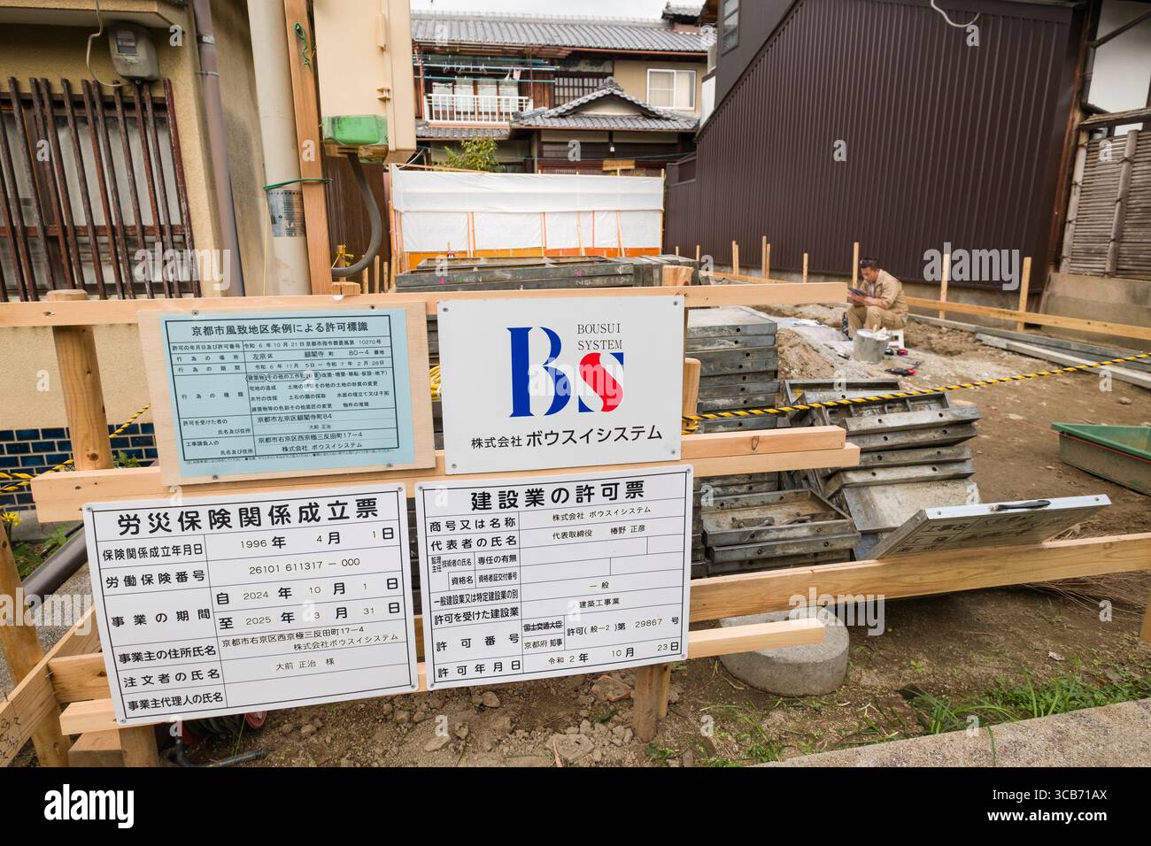 Un chantier de construction comporte un travailleur et des panneaux d'information, signifiant le développement urbain dans un quartier résidentiel, Kyoto, Japon Banque D'Images
