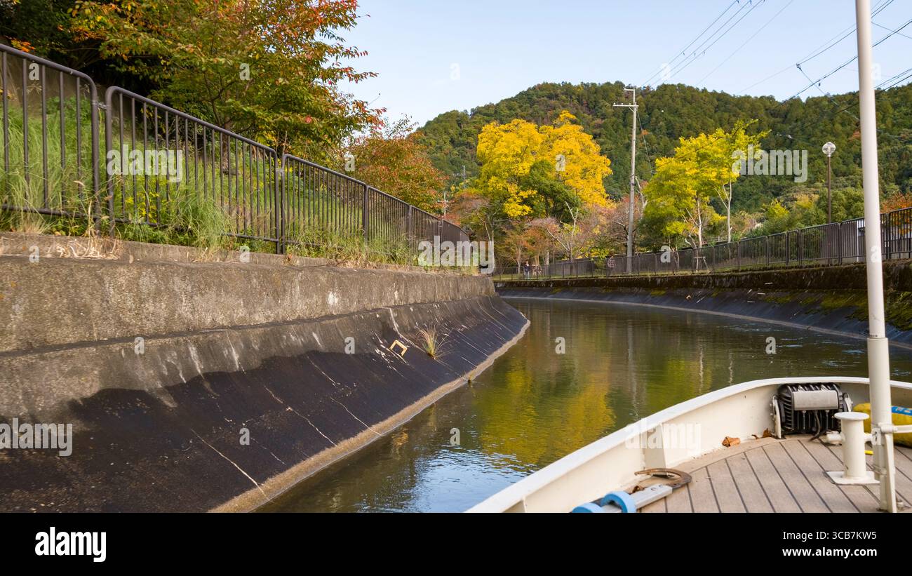 Belle scène d'un canal de banlieue du lac Biwa en automne, capturée à partir d'un bateau d'excursion, avec un feuillage jaune et orange vif, Kyoto, Japon Banque D'Images