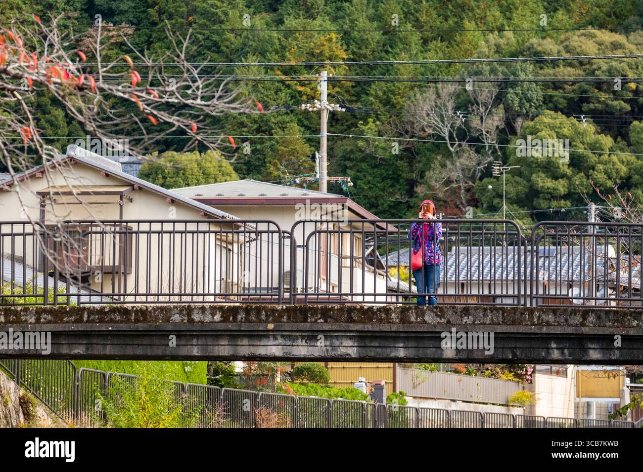Une personne se tient sur un pont dans une zone rurale entourée de verdure vue de la visite en bateau du canal du lac Biwa, Kyoto, Japon Banque D'Images