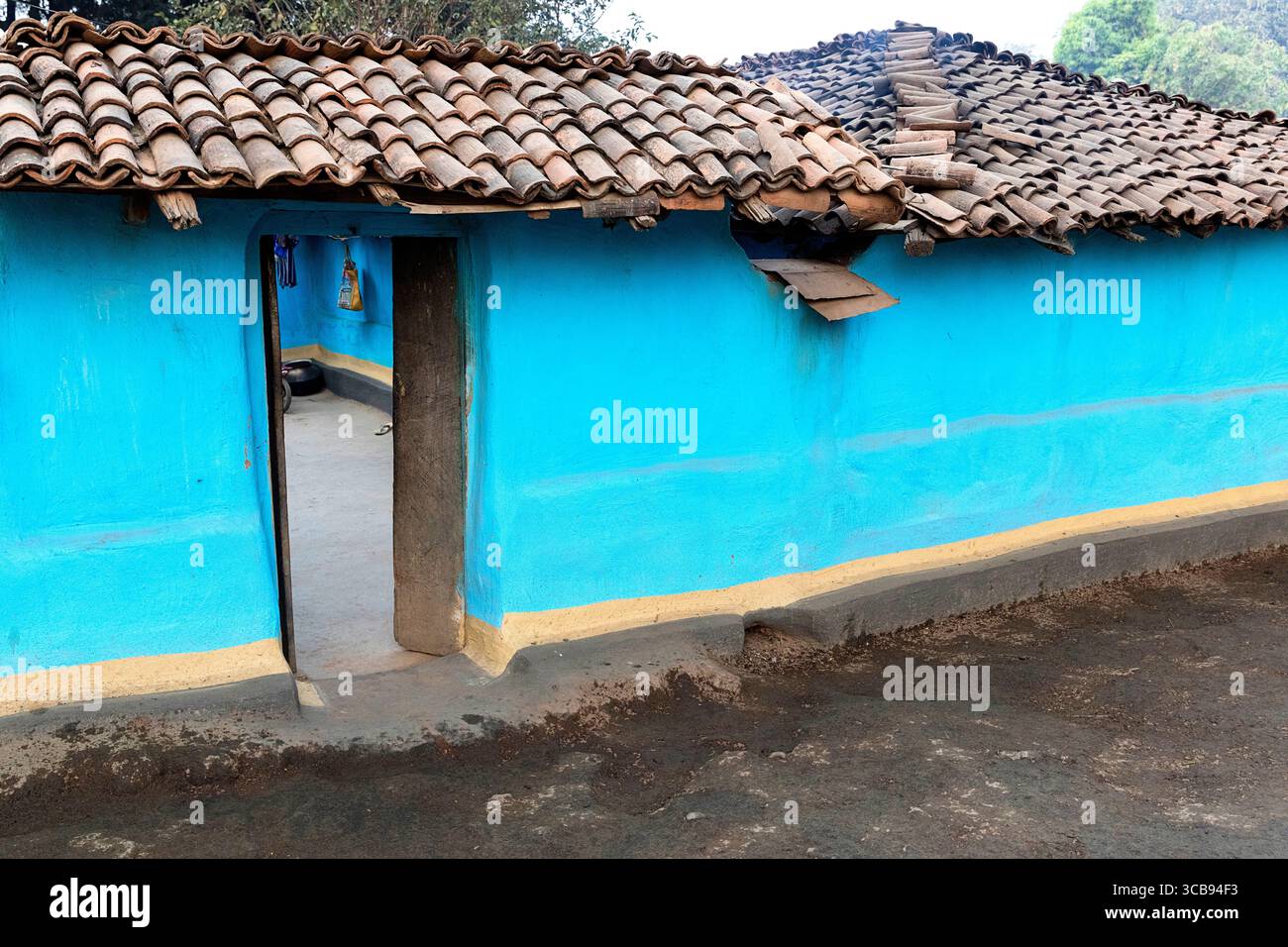 Maison traditionnelle faite de boue dans une partie éloignée de l'inde, maison bleue et entrée dans la cour de la maison Banque D'Images