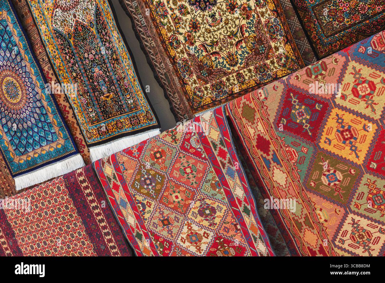 Tapis colorés faits à la main disposés symétriquement, mettant en valeur des motifs complexes et un savoir-faire traditionnel. Un affichage éclatant de l'art du tissage et du Cu Banque D'Images