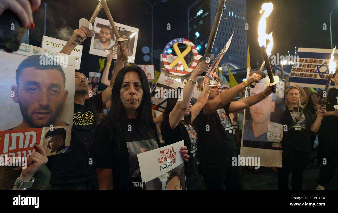 JÉRUSALEM - 7 AOÛT : Einav Zangauker, (C) dont le fils Matan est retenu en otage à Gaza, chante des slogans aux côtés des familles d'otages détenus à Gaza et d'anciens captifs alors qu'ils tiennent des torches et des pancartes portant des photos des otages lors d'une manifestation devant le bureau du premier ministre pendant que le cabinet de sécurité israélien se réunit pour décider si une prise de contrôle militaire complète de la bande de Gaza le 7 août 2025 à Jérusalem. Israël Banque D'Images JÉRUSALEM - 7 AOÛT : Einav Zangauker, (C) dont le fils Matan est retenu en otage à Gaza, chante des slogans aux côtés des familles d'otages détenus à Gaza et d'anciens captifs alors qu'ils tiennent des torches et des pancartes portant des photos des otages lors d'une manifestation devant le bureau du premier ministre pendant que le cabinet de sécurité israélien se réunit pour décider si une prise de contrôle militaire complète de la bande de Gaza le 7 août 2025 à Jérusalem. Israël Banque D'Images