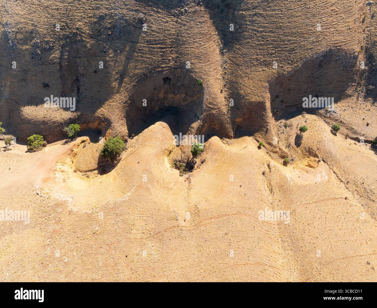 Vue aérienne d'un ravin sinueux à la base de collines érodées arides à Sellicks Beach sur la péninsule de Fluerieu en Australie méridionale. Banque D'Images