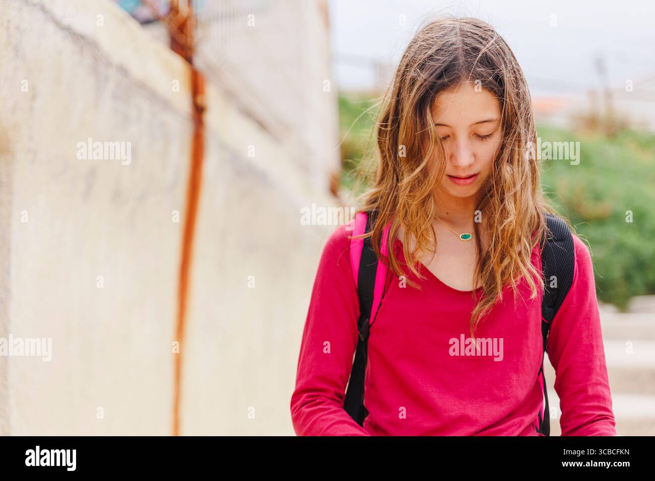 Portrait d'une belle fille avec les cheveux soufflés par le vent regardant vers le bas Banque D'Images