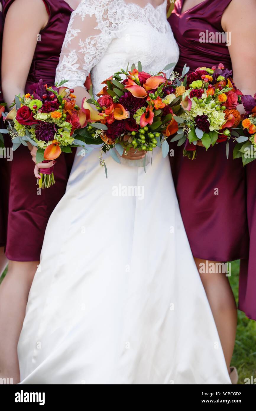 Mariée et demoiselles d'honneur en Bourgogne tiennent des bouquets d'automne. Banque D'Images Mariée et demoiselles d'honneur en Bourgogne tiennent des bouquets d'automne. Banque D'Images