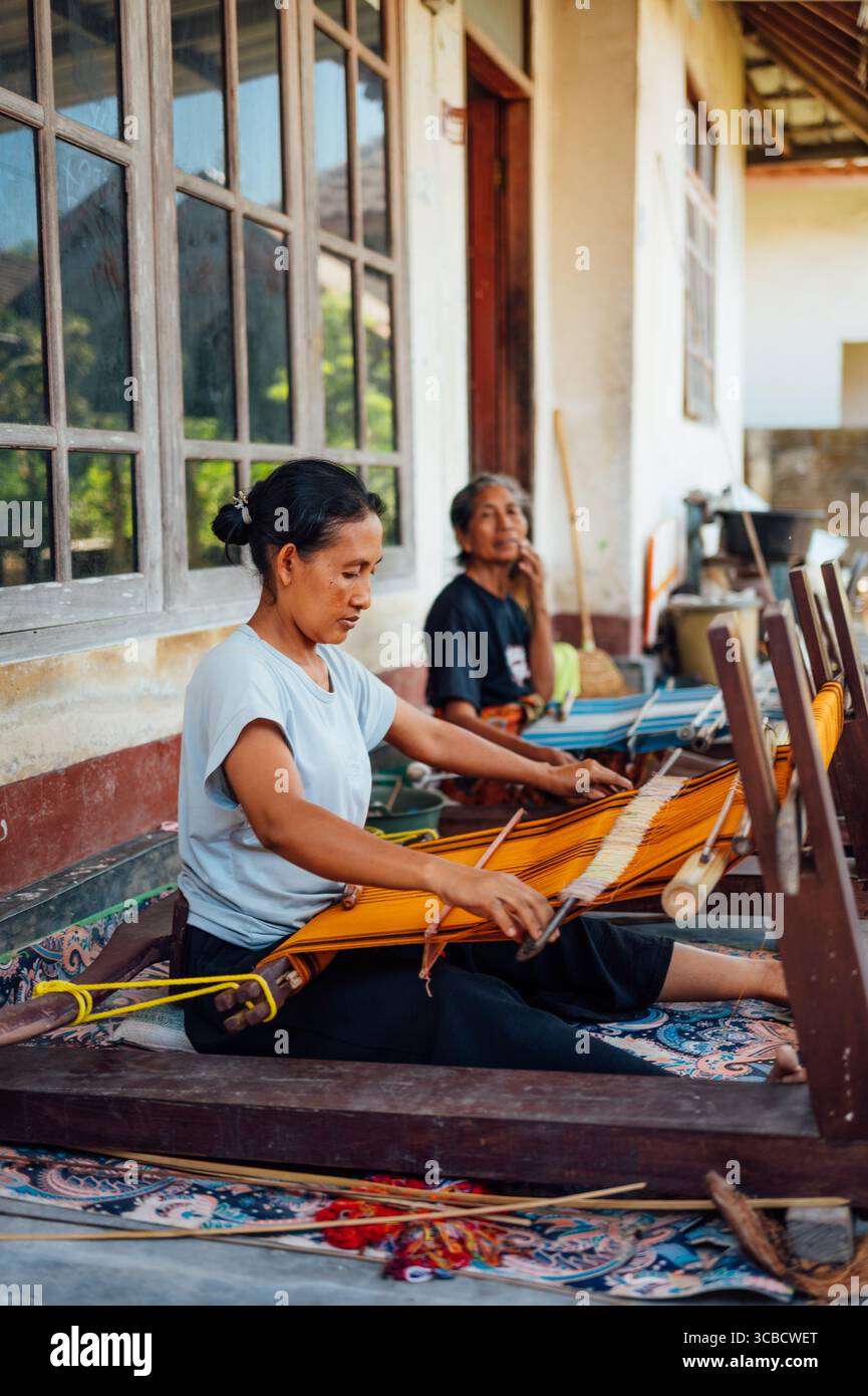Femmes tissant des textiles sur des métiers à tisser dos à Tetebatu, Lombok Banque D'Images