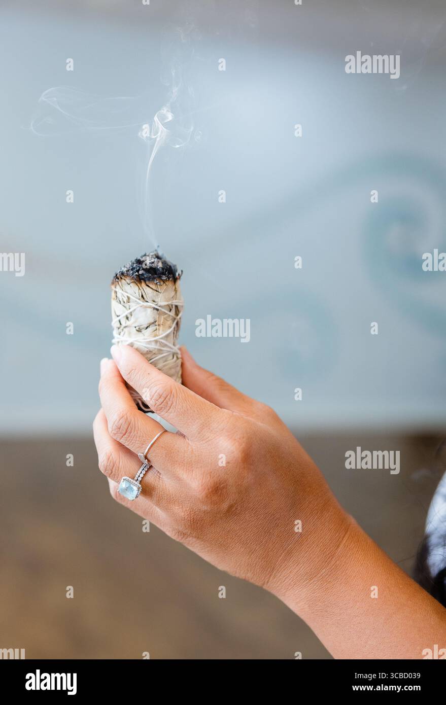 Femme tenant Smudge Stick de sauge avec de la fumée à Punta Gorda, Floride Banque D'Images