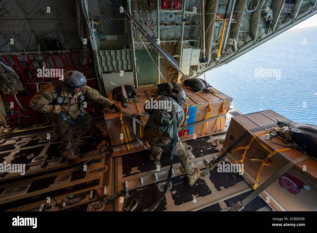 5 décembre 2023, atoll de Satawan, État de Chuuk, États fédérés de Micronésie : Joseph Snell, aviateur senior de l'US Air Force, à gauche, et le Sgt Matthew Muravez, maîtres de chargement du 36e escadron expéditionnaire de transport aérien se préparent à pousser un paquet humanitaire hors d'un avion C-130J Super Hercules de l'US Air Force pendant l'opération Christmas Drop, le 5 décembre 2023 dans l'atoll de Satawan, Micronésie. L’opération Christmas Drop est la plus ancienne mission humanitaire et de secours en cas de catastrophe, livrant 71 000 livres de nourriture, de cadeaux et de fournitures pour aider les communautés insulaires éloignées du Pacifique Sud. (Crédit image : © Yasuo Osaka Banque D'Images