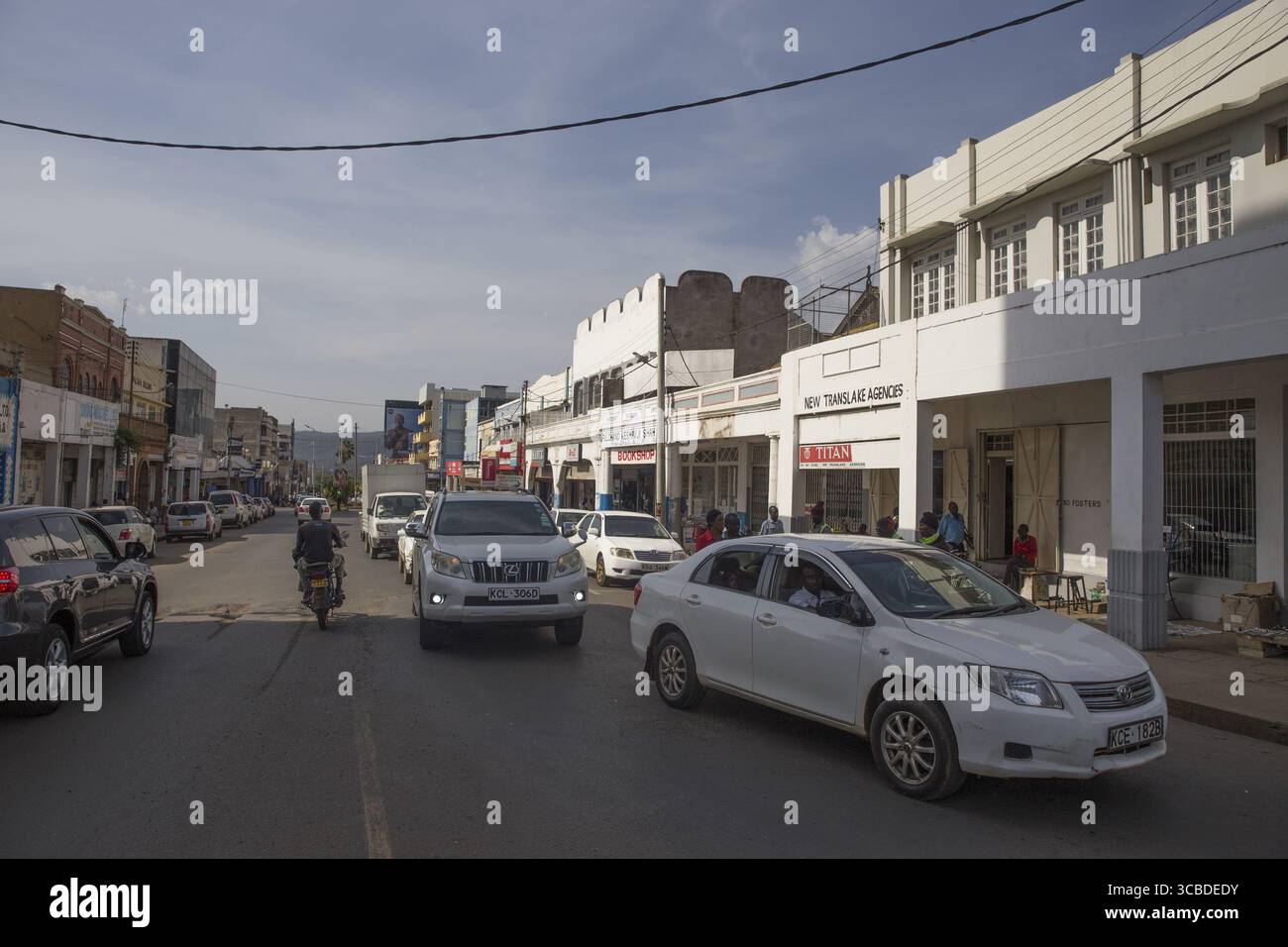 Kisumu, Kenya - 13 mai 2021 : vue d'une scène de rue animée avec des voitures et des piétons au milieu de l'architecture coloniale sous un ciel lumineux. Banque D'Images