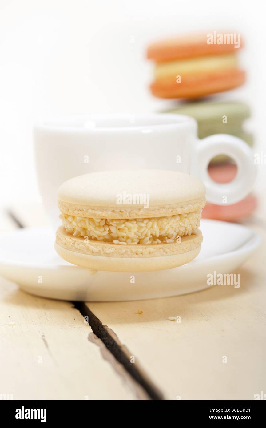Macarons colorés avec café expresso sur table en bois blanc Banque D'Images