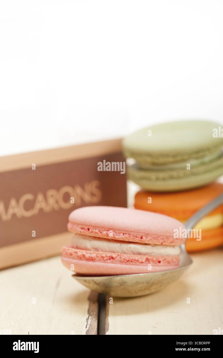 Macarons français colorés sur une table en bois rustique blanc Banque D'Images