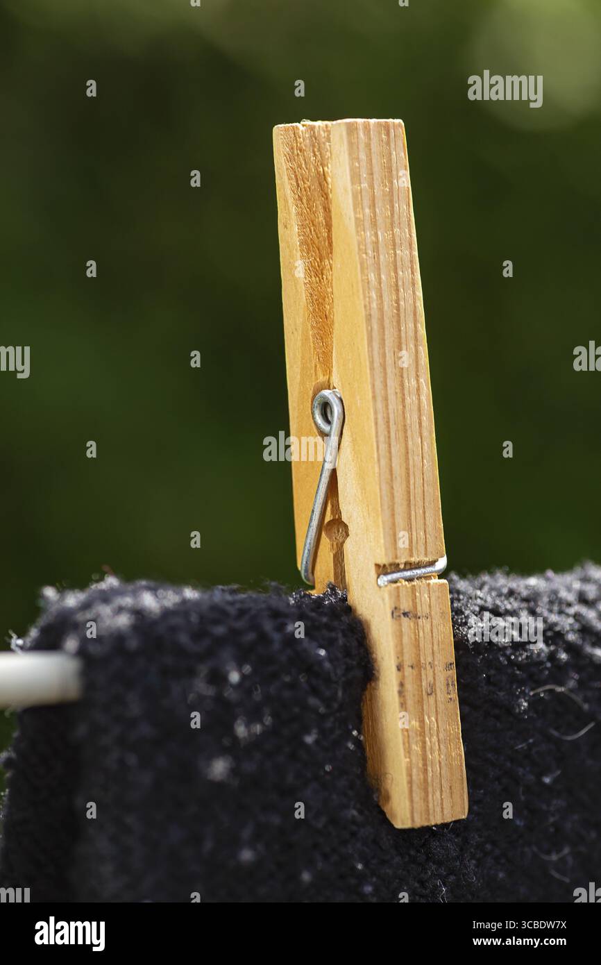 Gros plan d'une épingle de corde à linge en bois tenir une chemise noire sur une ligne Banque D'Images