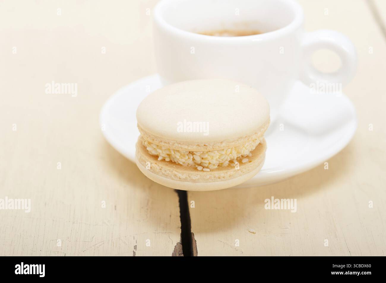 Macarons colorés avec café expresso sur table en bois blanc Banque D'Images