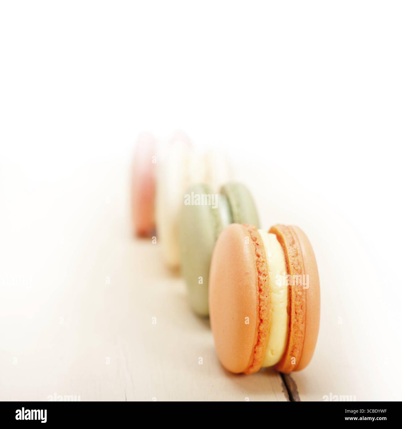 Macarons français colorés sur une table en bois rustique blanc Banque D'Images