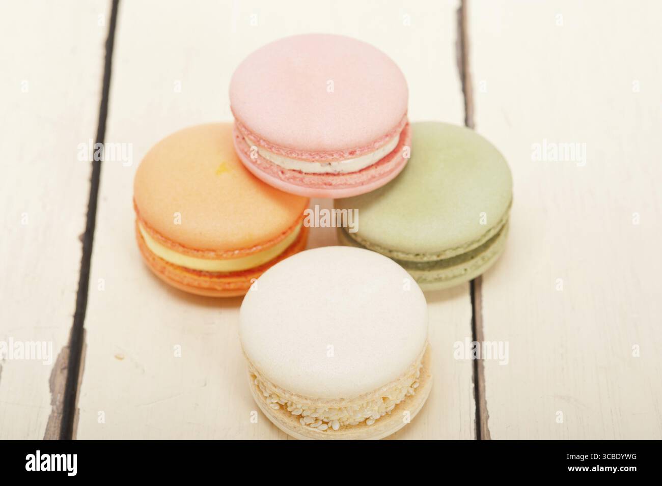 Macarons français colorés sur une table en bois rustique blanc Banque D'Images