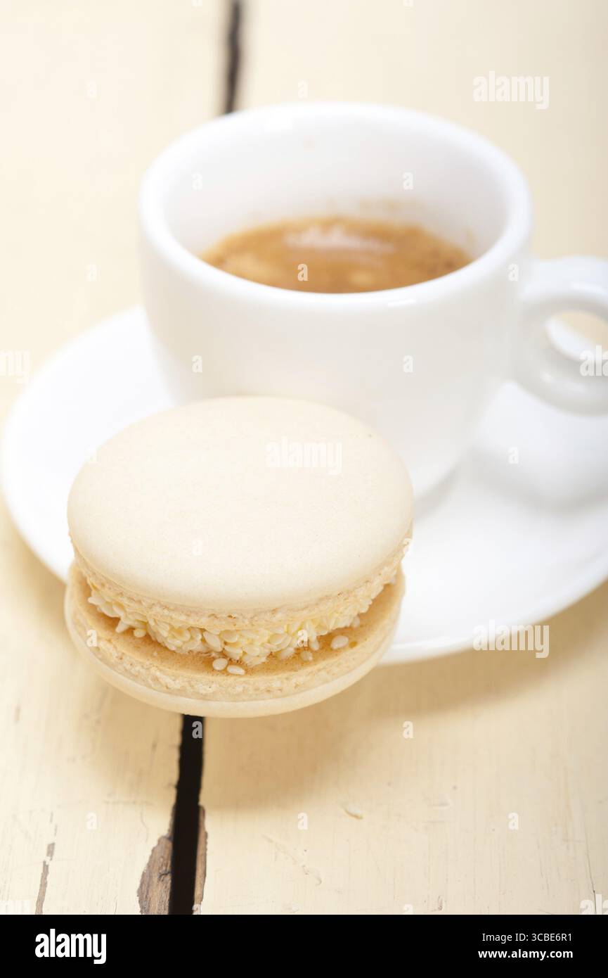 Macarons colorés avec café expresso sur table en bois blanc Banque D'Images