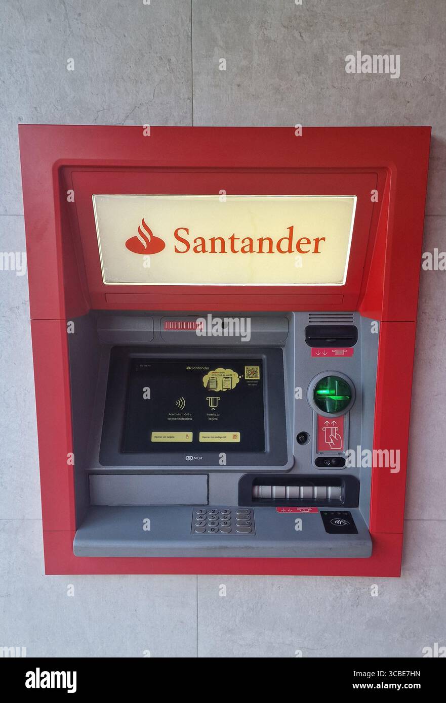 Guichet automatique au design rouge vif et à l'écran lumineux, offrant un accès facile aux services bancaires et aux retraits d'espèces dans un cadre contemporain Banque D'Images