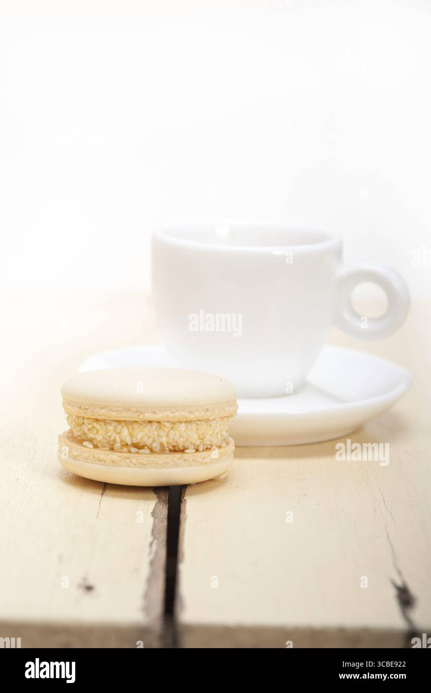Macarons colorés avec café expresso sur table en bois blanc Banque D'Images