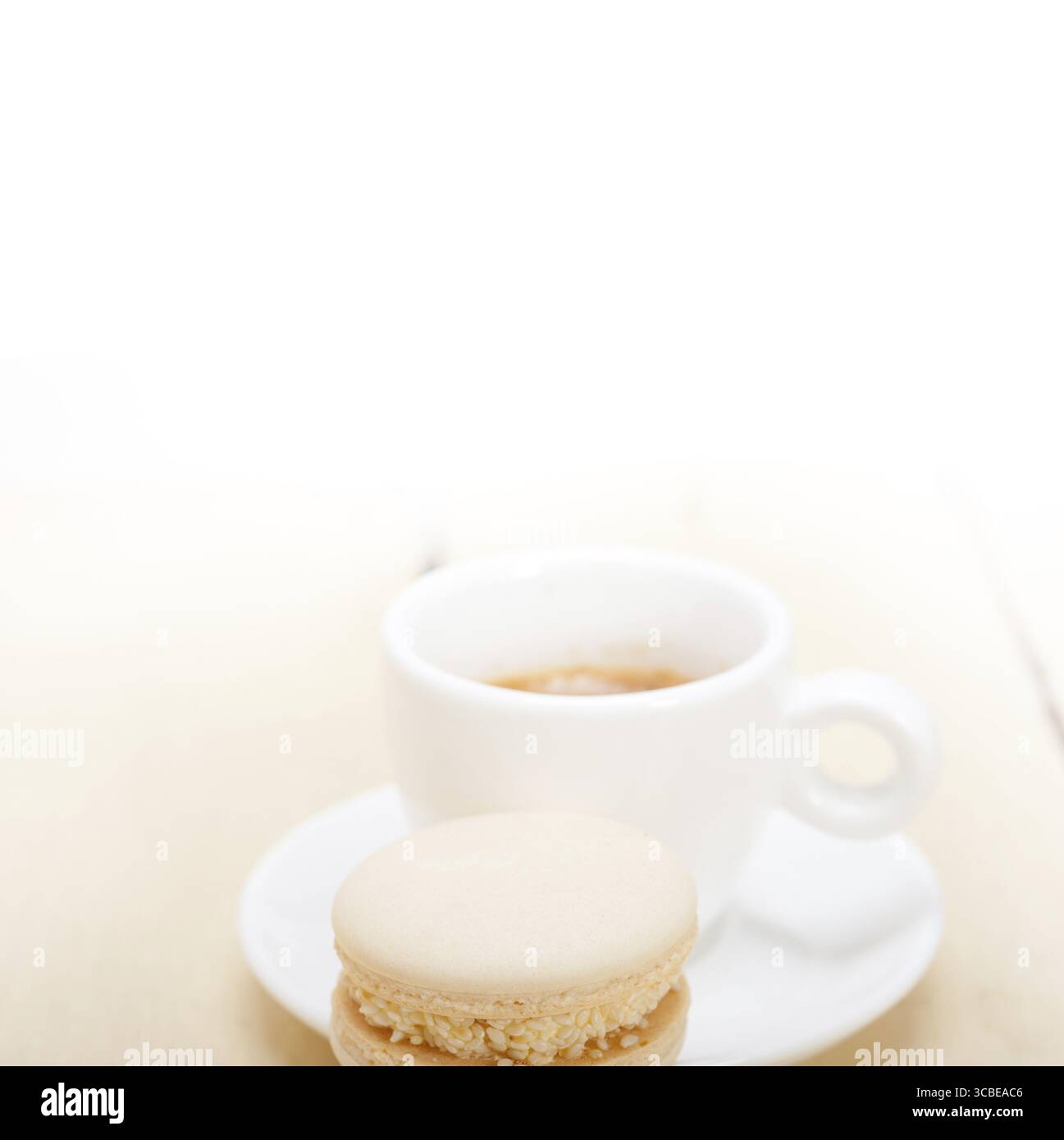 Macarons colorés avec café expresso sur table en bois blanc Banque D'Images