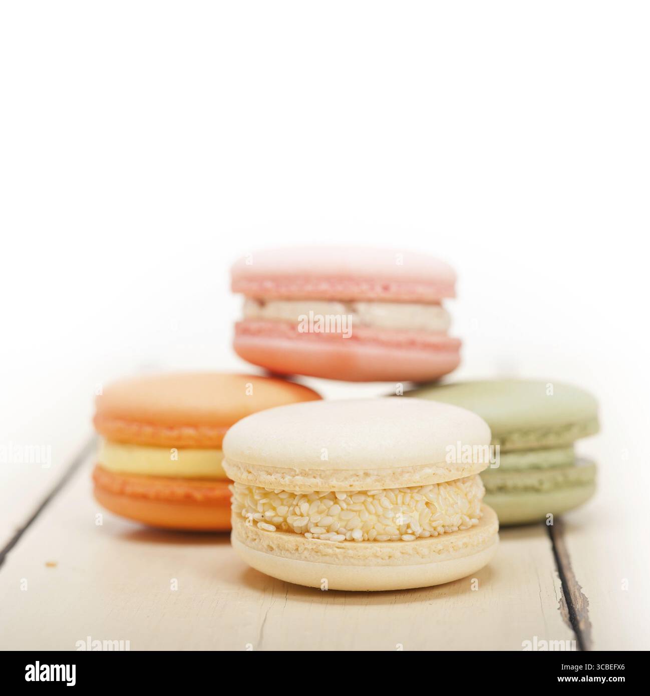 Macarons français colorés sur une table en bois rustique blanc Banque D'Images