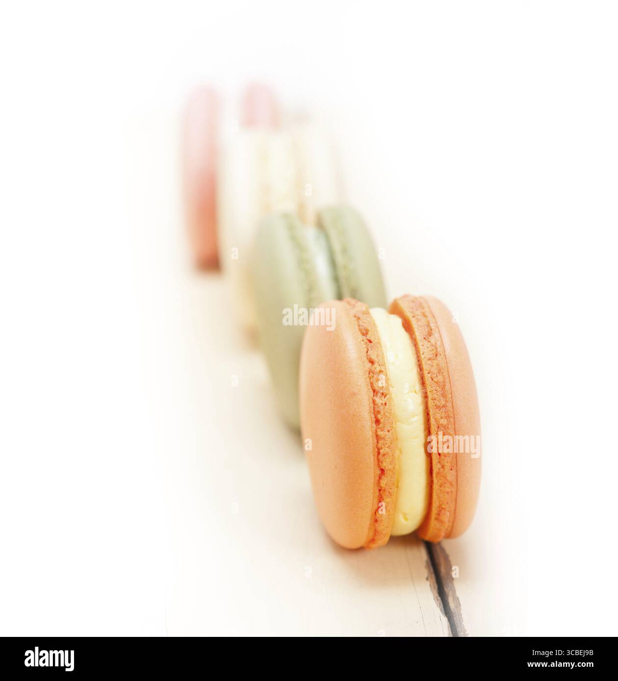 Macarons français colorés sur une table en bois rustique blanc Banque D'Images