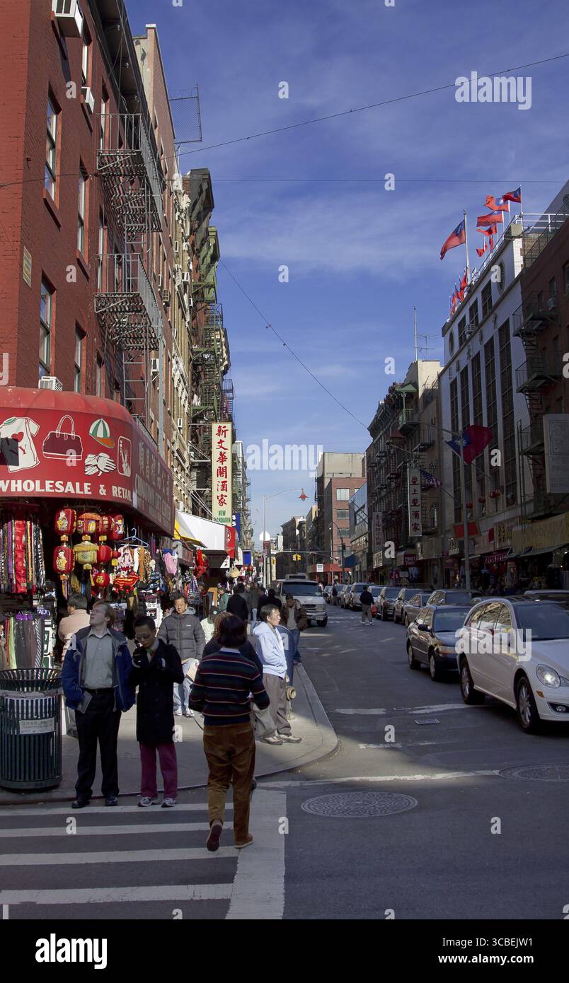 Des acheteurs attendent au coin de la rue devant un magasin de souvenirs dans le quartier chinois de New York Banque D'Images