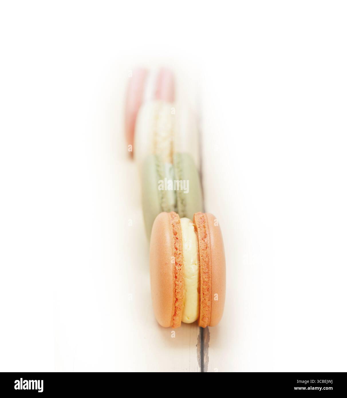 Macarons français colorés sur une table en bois rustique blanc Banque D'Images
